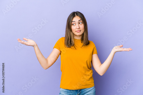 Young caucasian woman confused and doubtful shrugging shoulders to hold a copy space. © Asier