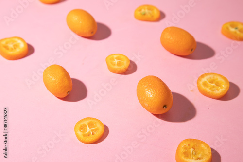 kumquat orange fruit on pink background