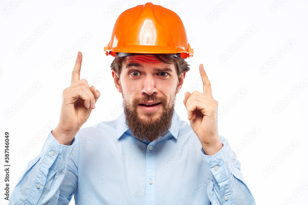 A man gestures with his hands an engineer orange hard hat safety construction A man gestures with his hands an engineer orange hard hat safety construction