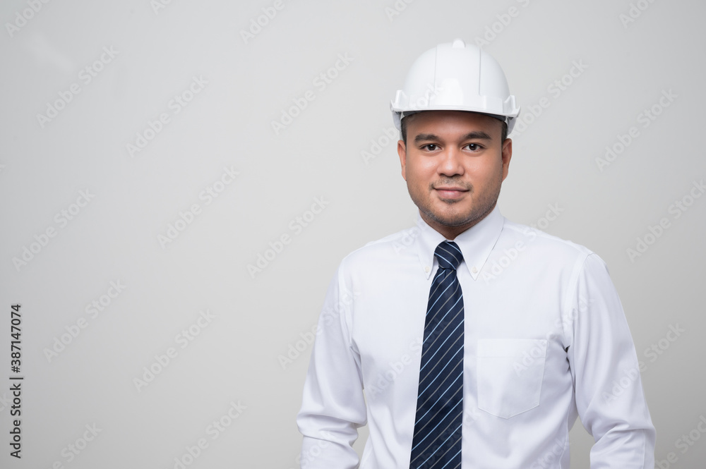 Smiling young asian civil engineer wearing helmet hard hat standing on isolated white background. Mechanic service concept. Smiling young asian civil engineer wearing helmet hard hat standing on isolated white background. Mechanic service concept.