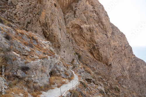 Tourist on the mountain path, Thira island, Greece.
