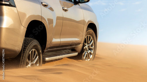 Close up of a golden car stuck in the sand in the Namib desert. © Yuliia Lakeienko