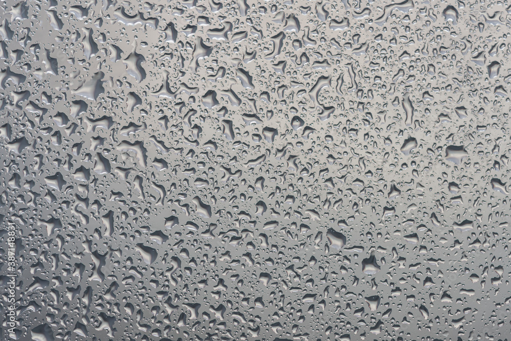 water drops on glass background texture. rain on the grey window