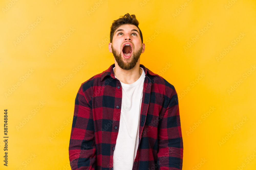 Young caucasian man isolated on yellow background shouting very angry, rage concept, frustrated. Young caucasian man isolated on yellow background shouting very angry, rage concept, frustrated.