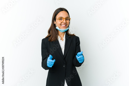 Young business latin woman wearing a mask to protect from covid isolated on white background with thumbs ups, cheers about something, support and respect concept.