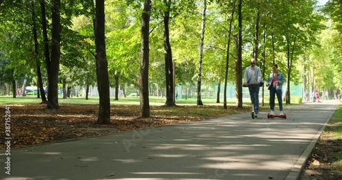 Wallpaper Mural Young woman on segway talking with old businessman riding e scooter at park Torontodigital.ca