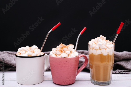 Pumpkin spice latte with cinnamon and white pumpkins on wooden and black background. Harvest season and cozy pumpkin food backdrop. Space for writing. Hot chocolate with marshmallow. 