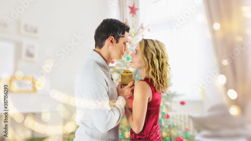 Happy couple at home in Christmas with gifts