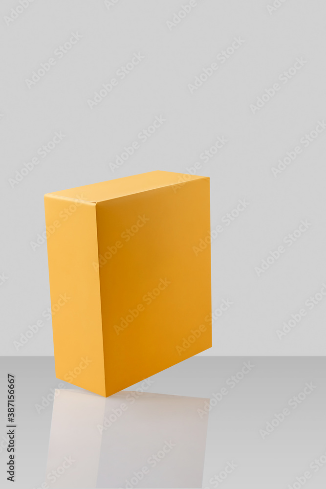 Yellow orange closed cardboard box or carton on grey background, template, mockup, sideview. Yellow orange closed cardboard box or carton on grey background, template, mockup, sideview.