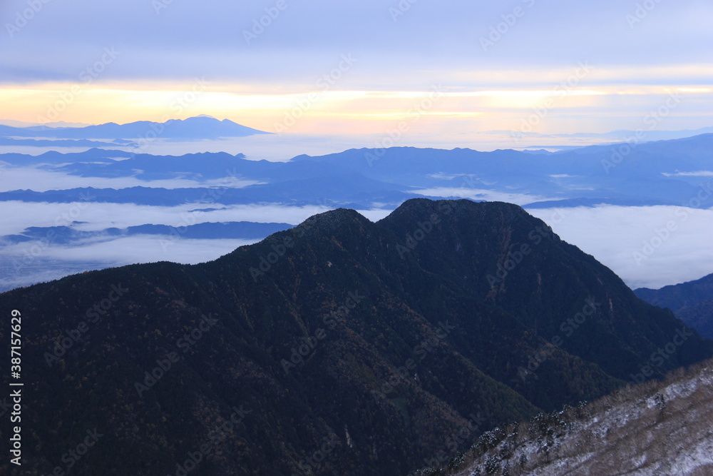 Fototapeta premium 北アルプスの朝 燕岳からの風景 有明山シルエット越しの朝焼けと雲海と浅間山遠景 