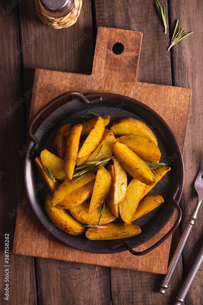 Delicious slices of baked potatoes with rosemary and oil Delicious slices of baked potatoes with rosemary and oil
