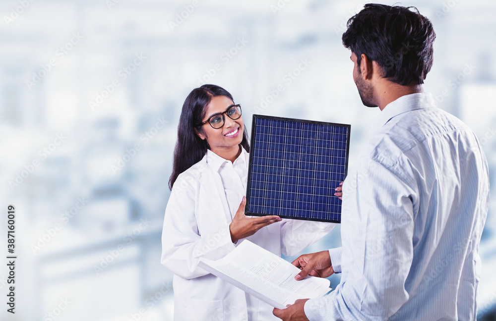 Fototapeta premium Two Indian scientists looking at solar battery