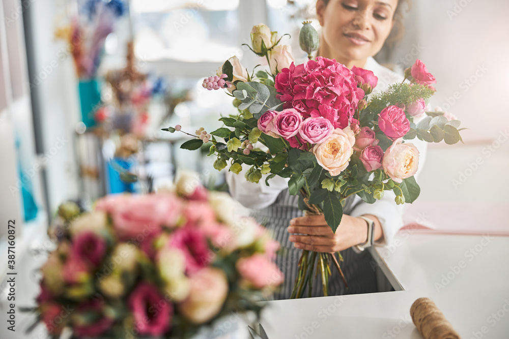 Fototapeta premium Professional florist posing with a gorgeous floral composition