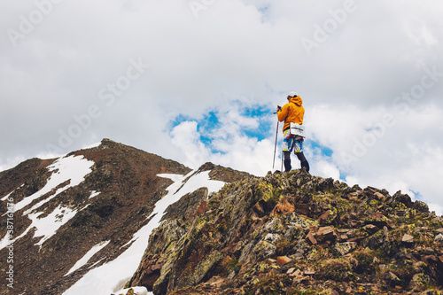 Man hiker using smartphone application navigation in mountains back portrait