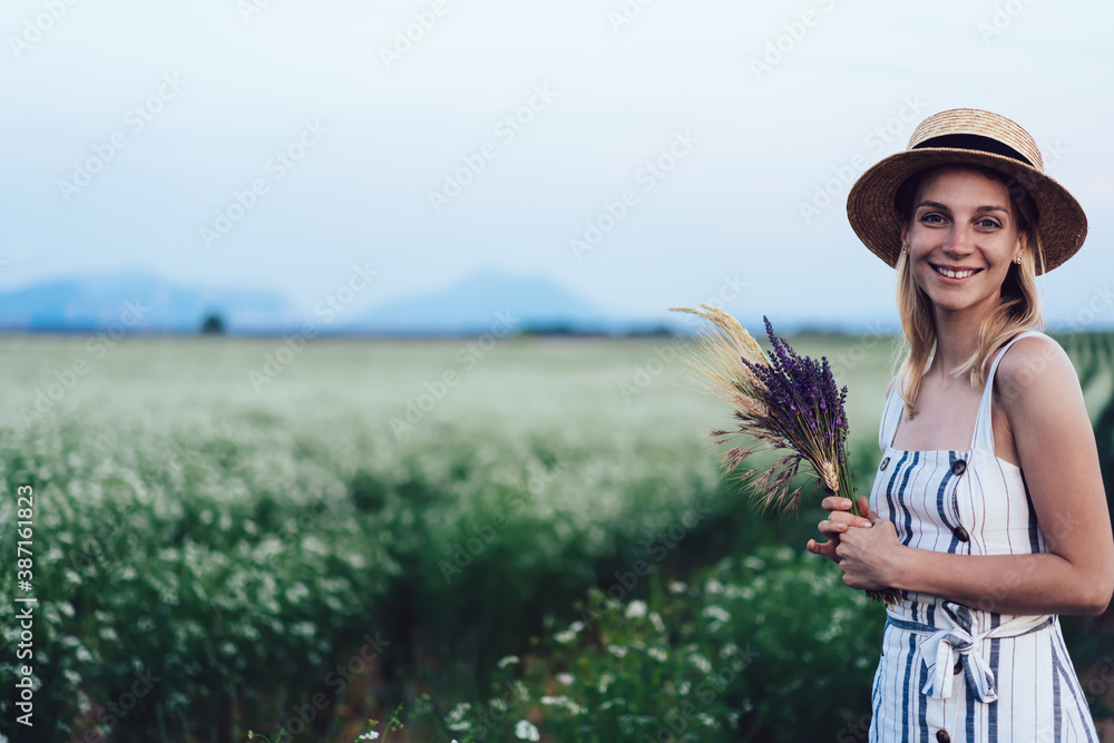 Cheerful woman standing amidst lines with flowers