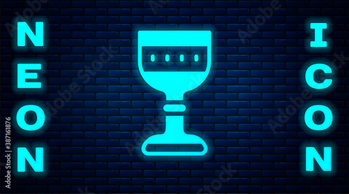 Glowing neon Medieval goblet icon isolated on brick wall background. Vector.