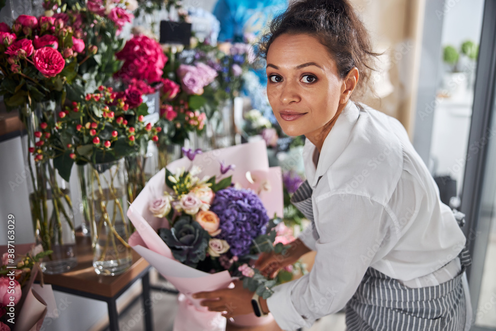 Busy female florist sorting out bouquets on a dispaly