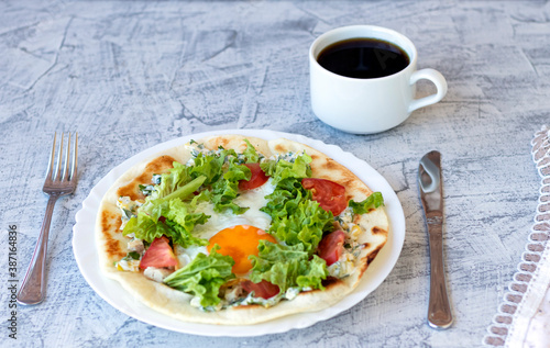 Italian breakfast with coffee. Piadina with egg, tomatoes and salad. Delicious breakfast served on table with napkin.