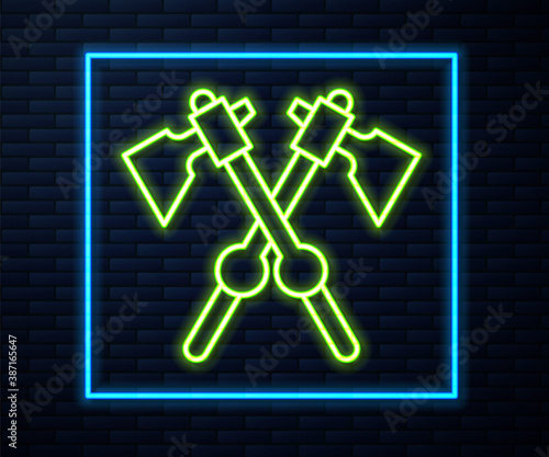 Glowing neon line Crossed medieval axes icon isolated on brick wall background. Battle axe, executioner axe. Medieval weapon. Vector.