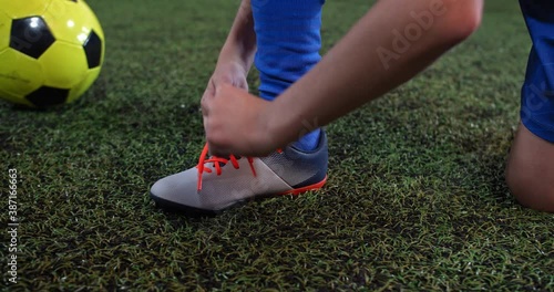 Football player getting ready for the game tying his shoes