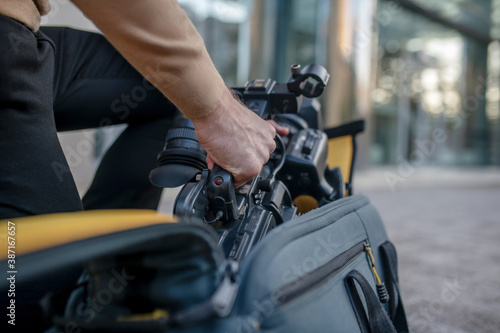 Close-up of male hands taking camera out of the case