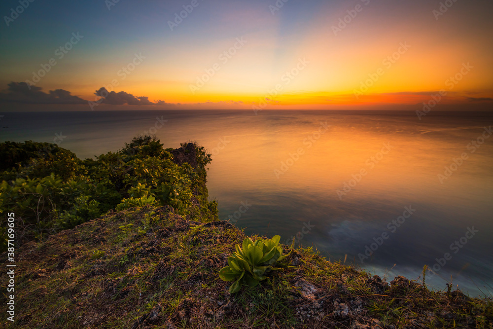 Seascape. Spectacular view from Uluwatu cliff in Bali. Sunset time. Blue hour. Ocean view. Colorful sky. Nature concept. Soft focus. Slow shutter speed.