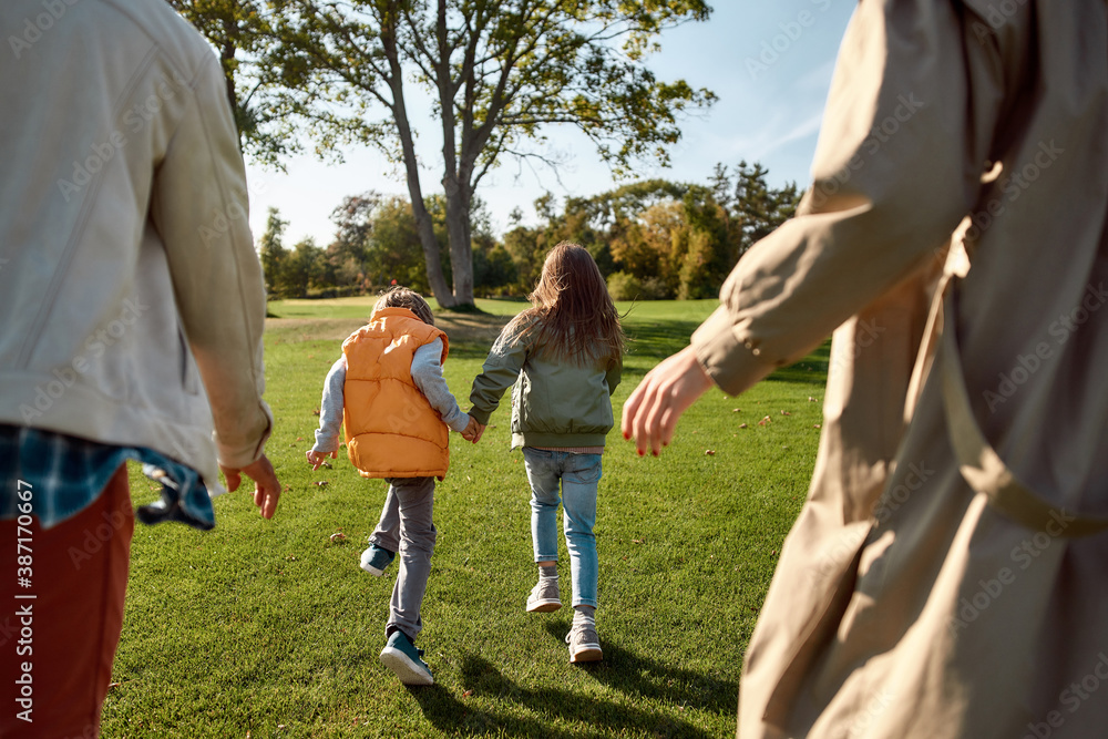 Fototapeta premium We are closer. Excited family running outdoors on a sunny day