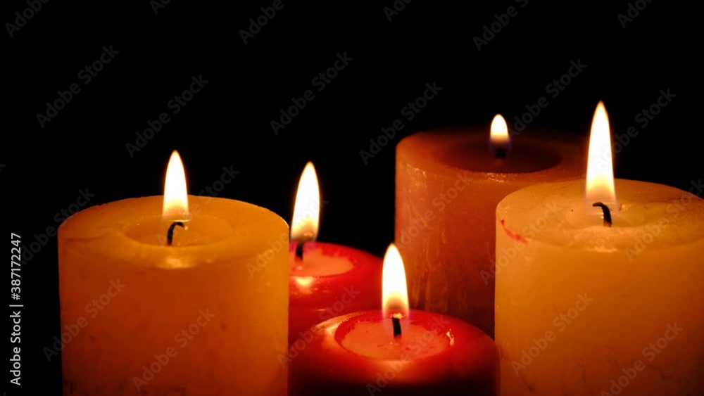 Thick commemorative candles burn on black background in 4k resolution video clip close-up Thick commemorative candles burn on black background in 4k resolution video clip close-up