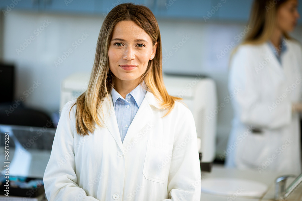 Female scientist in white lab coat standing in the biomedical lab Female scientist in white lab coat standing in the biomedical lab