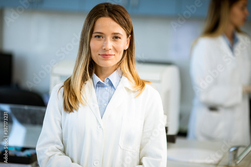 Female scientist in white lab coat standing in the biomedical lab Free Download Female scientist in white lab coat standing in the biomedical lab - GFXLoad