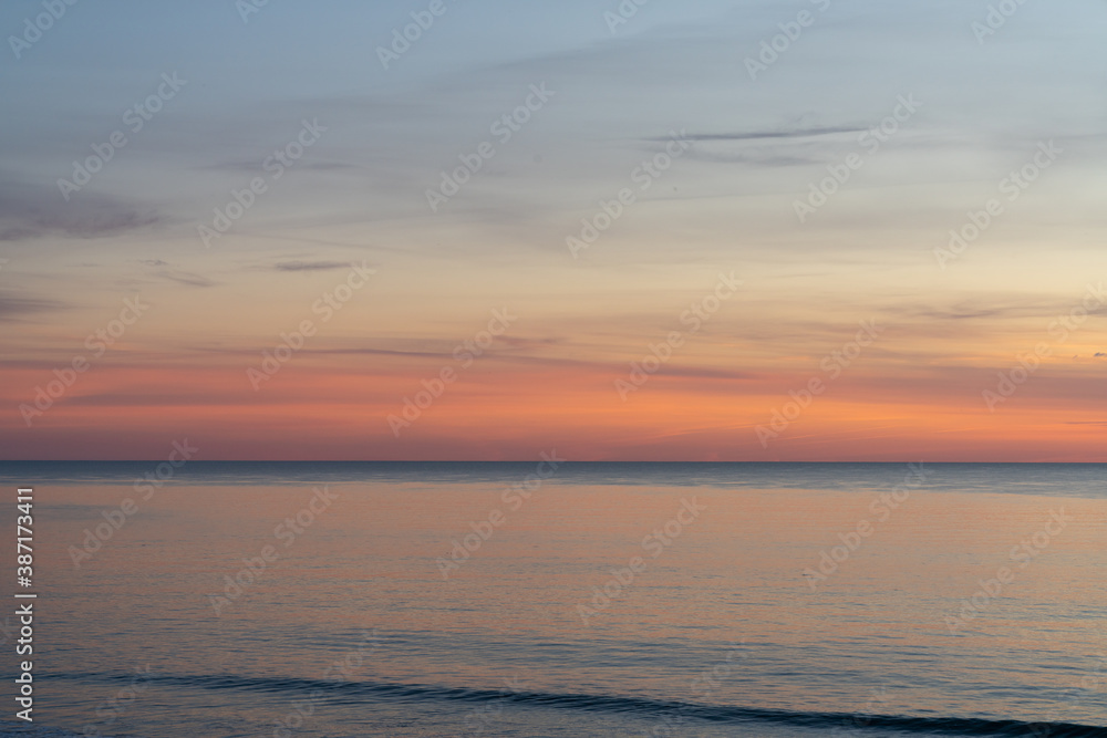 Obraz premium beautiful sunset over the ocean with colorful sky and small waves