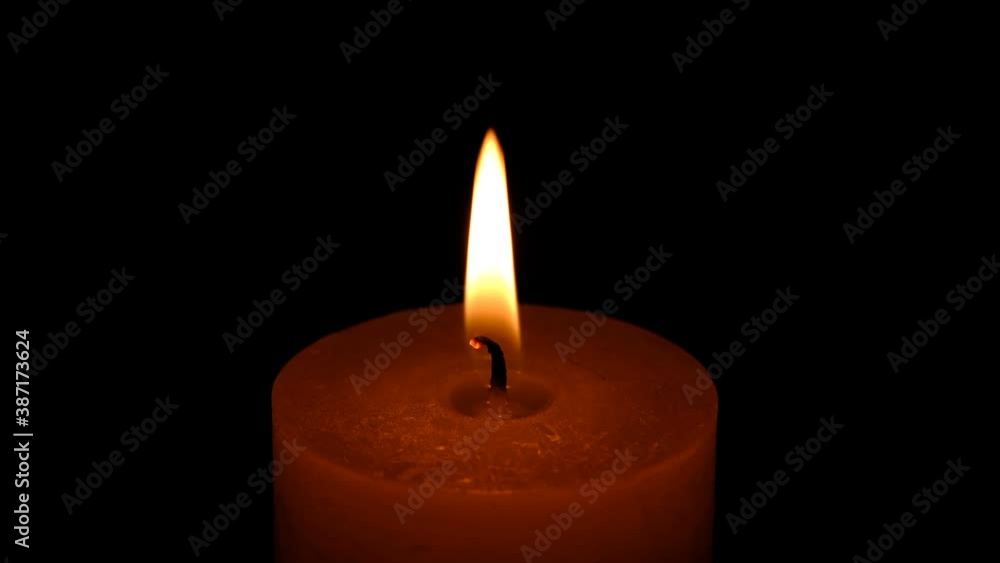 Thick candle is burning on a black background in memory of deceased people 4k resolution video clip close-up Thick candle is burning on a black background in memory of deceased people 4k resolution video clip close-up