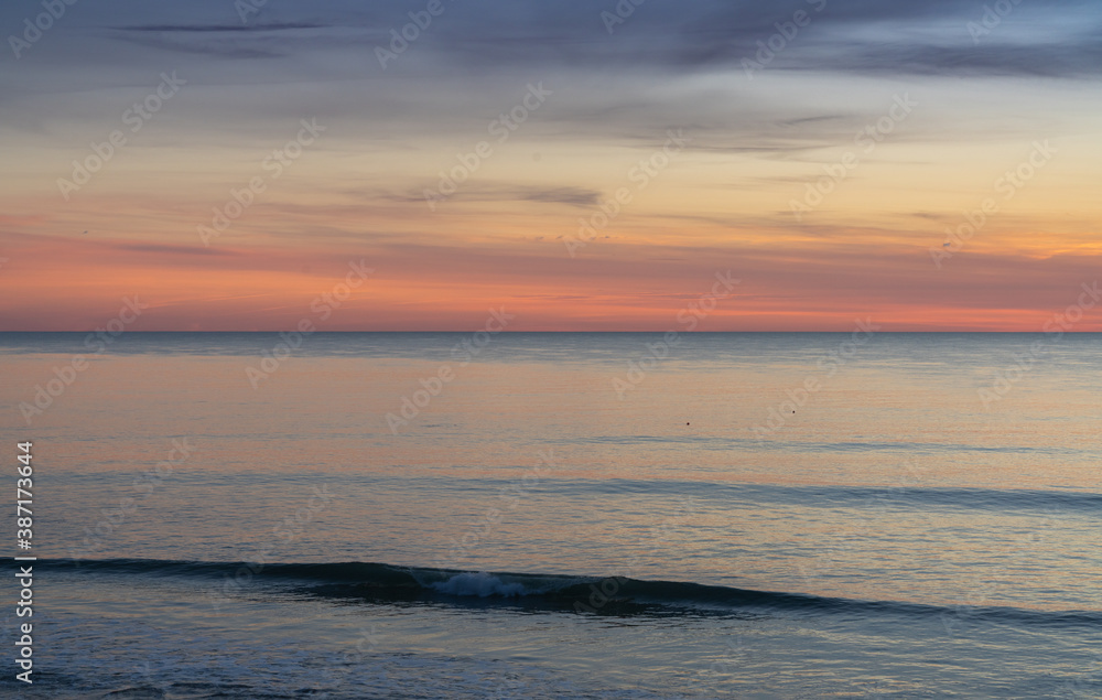 Obraz premium beautiful sunset over the ocean with colorful sky and small waves