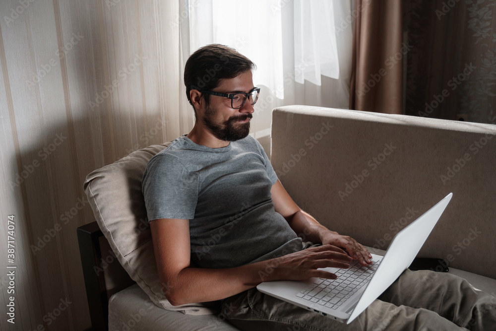 Remote Job. Man Working On Laptop Sitting On Sofa At Home. Remote Job. Man Working On Laptop Sitting On Sofa At Home.