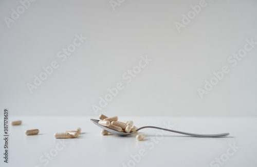 Daily Fiber Supplement. Pills in capsules on spoon. 