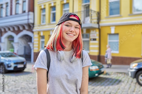 Portrait of fashionable hipster teenage girl with colored dyed hair in black cap photo