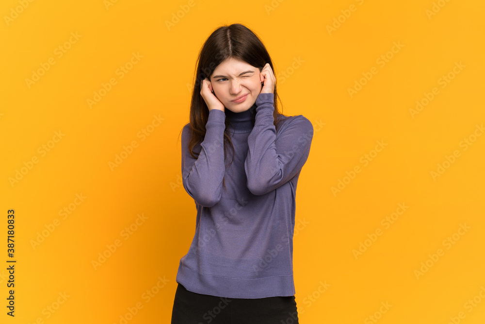 Young Ukrainian girl isolated on yellow background frustrated and covering ears Young Ukrainian girl isolated on yellow background frustrated and covering ears