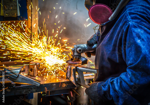worker cutting steel with grinder