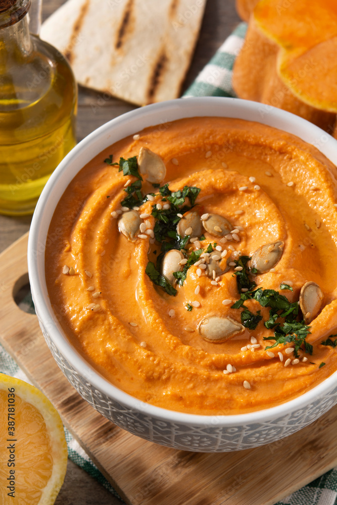 Pumpkin hummus and ingredients on wooden table Pumpkin hummus and ingredients on wooden table