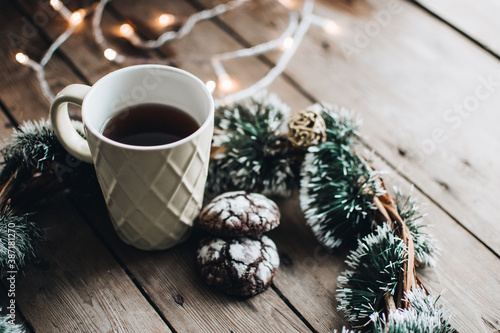 Christmas styled composition. Winter still life. Scandinavian hygge concept. Morning concept. Cozy winter scene with hot tea or coffee and cookies. Flat lay. Home decor.