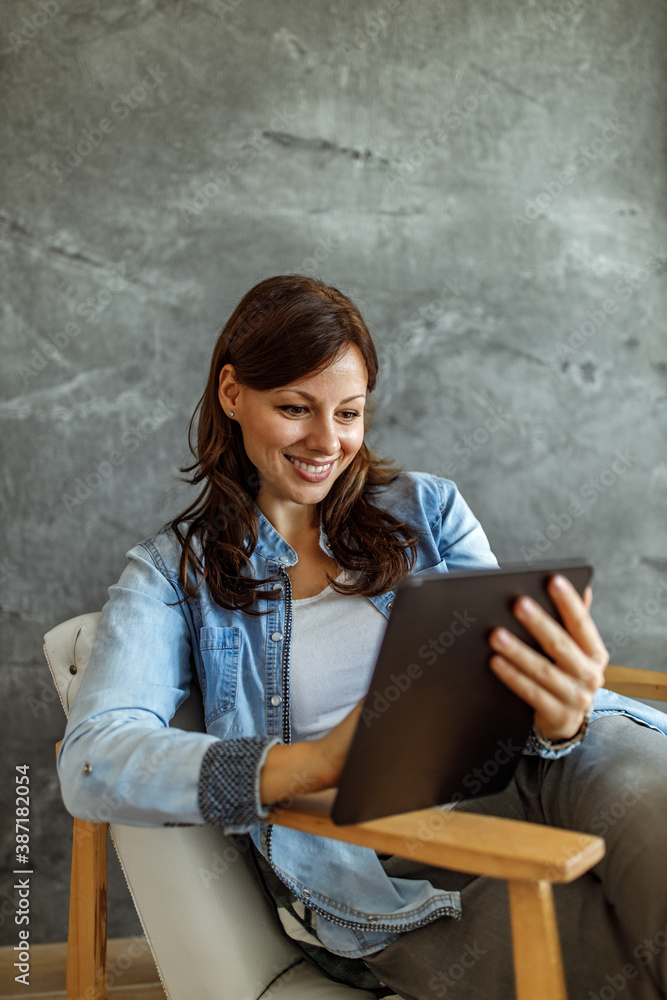 Woman sitting in her living room, working online. Woman sitting in her living room, working online.