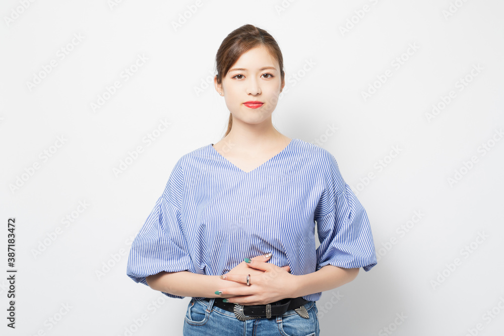 お腹に手を当てる若い女性 お腹に手を当てる若い女性