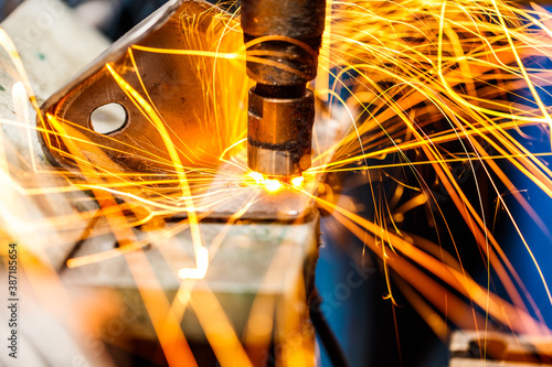 Spot machine is welding nut to automotive part.