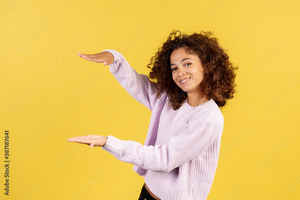 Young afro american woman on yellow copy space background Young afro american woman on yellow copy space background