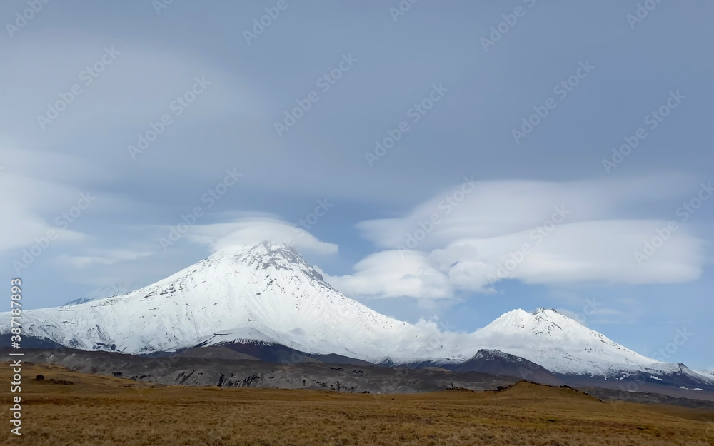 Fototapeta premium A magnificent view of the volcanoes of central Kamchatka. Picturesque mountains, hills and plains.