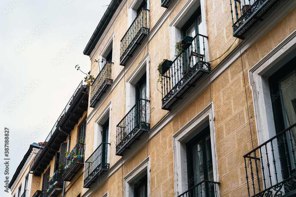 Low angle view of traditional cast iron balconies of old residential building in Lavapies quarter in central Madrid