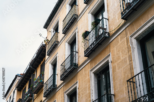 Low angle view of traditional cast iron balconies of old residential building in Lavapies quarter in central Madrid