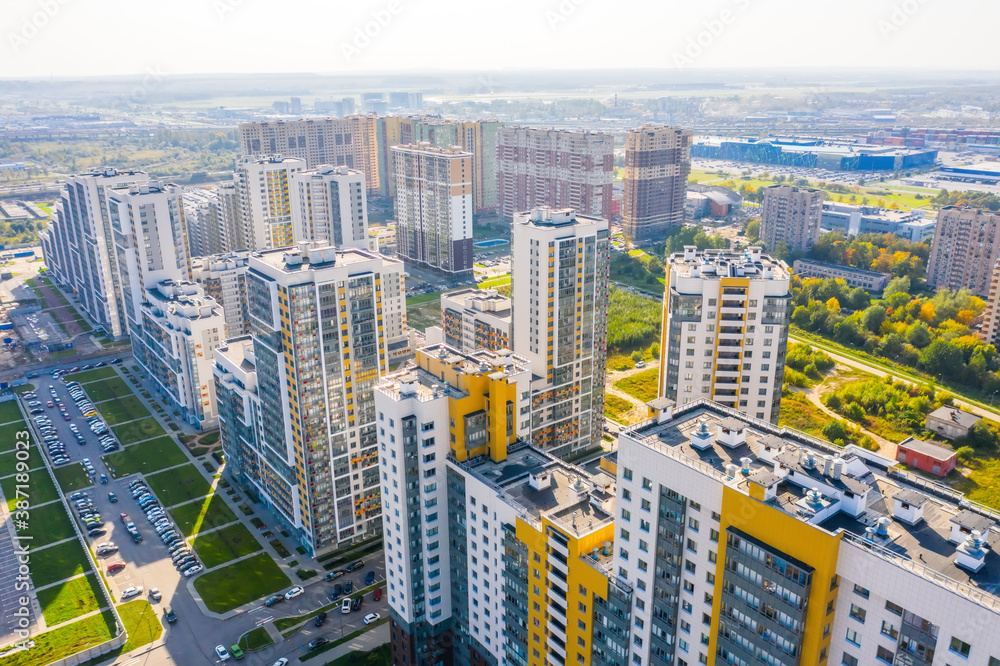 Fototapeta Panoramic aerial view of the city with multi-storey residential buildings and highways.