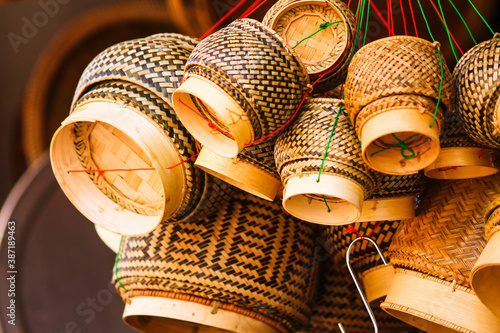 Kratips or traditional woven rice containers hanging in a market stall in Luang Prabang Laos photo