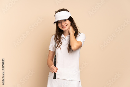 Young Ukrainian golfer girl isolated on beige background laughing